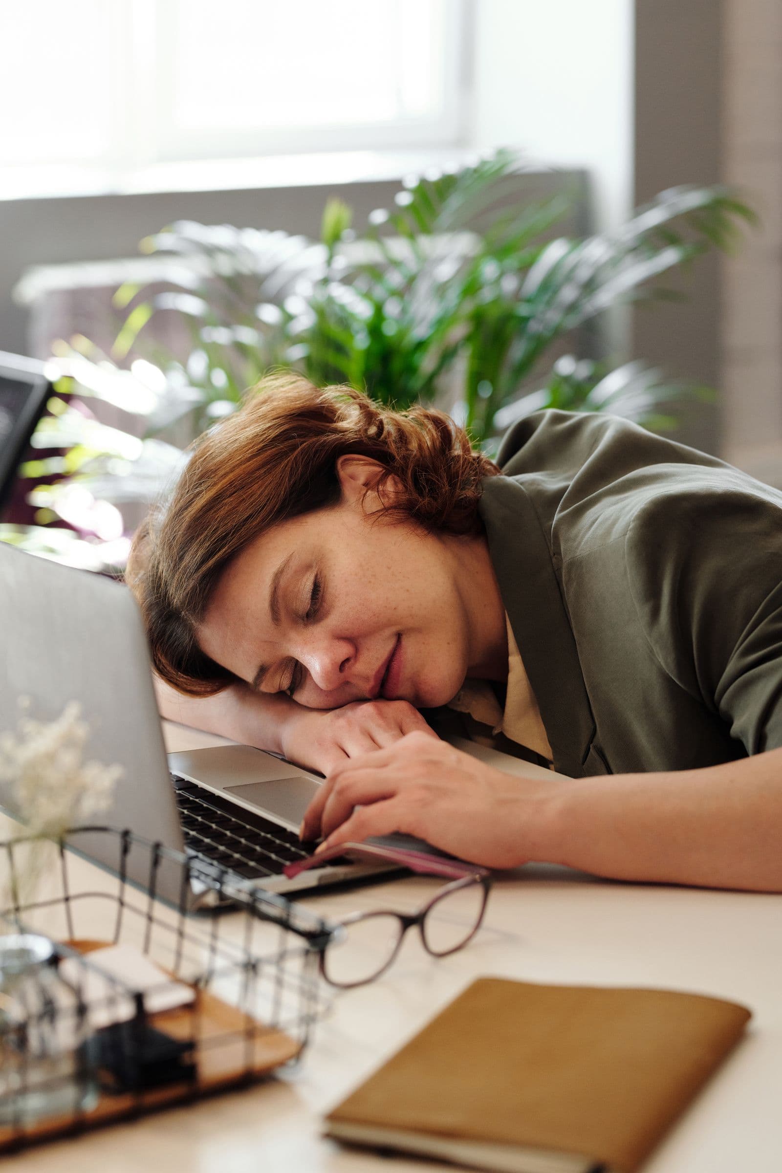 A person asleep at a laptop after work